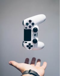 white PS4 controller hovering above a hand